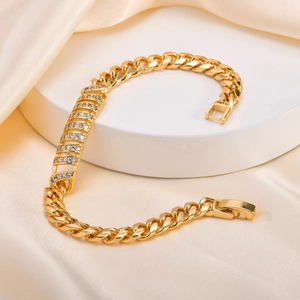 Elegant gold-tone Cuban link bracelet with sparkling zircon pavé on white display stand