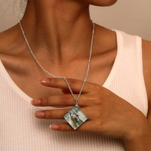 Close-up of personalized silver square locket necklace on a model showing actual size