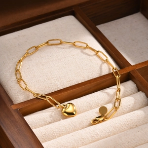 Détail d'un bracelet à pendentif cœur en or 18 carats avec maillons dans un écrin à bijoux