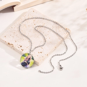 Close-up of a silver custom photo pendant necklace with a clear glass cabochon