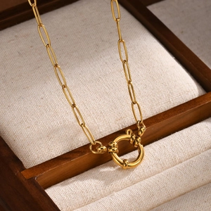 Macro detail of 18K gold plated paperclip chain necklace with a circular bubble clasp closure