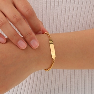 Gold stainless steel pearl chain bracelet with rectangular curved plate worn on wrist
