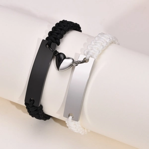Detail of magnetic heart clasp connecting black and white woven couple bracelets