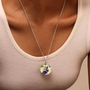 Close-up of a personalized silver necklace with a custom photo pendant on a model