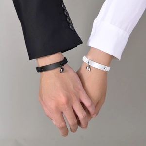 Detailed view of magnetic heart charm on woven couple bracelets with customizable bar