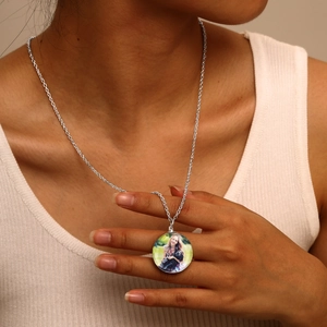 Close-up of a silver-toned custom photo pendant necklace worn by a female model