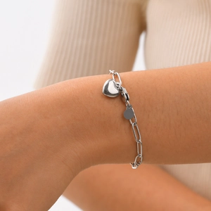 Détail du bracelet en maille trombone argentée avec pendentif cœur porté au poignet