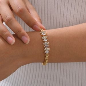 Close-up of a gold-plated Cuban chain bracelet with sparkling marquise zircon inlays