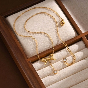 Détail du collier pendentif papillon doré avec gland en zircon sur un coffret à bijoux