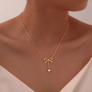 Collier nœud doré avec pendentif en zircon porté par un mannequin sur la peau