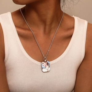 Close-up of a personalized silver rectangular photo pendant necklace worn by a model