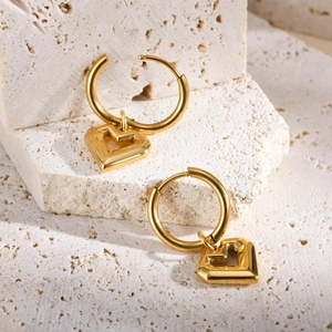 Boucles d'oreilles créoles dorées en forme de cœur sur socle en pierre texturée