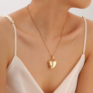 Pendentif cœur doré poli sur chaîne en O porté par un mannequin sur fond en soie
