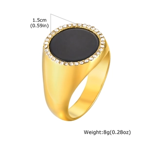 Détail de chevalière dorée en acier avec pierre d'onyx noire et halo de zircons