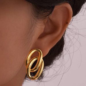 Detail shot of a model wearing golden double hoop earrings with a high-polished finish