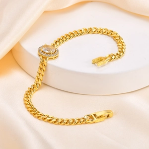 Macro shot of gold Cuban chain bracelet featuring oval zircon center stone on display