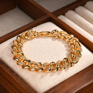 Close-up of gold Cuban link bracelet with pavé zircons on a luxury display box
