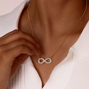 Gold infinity necklace with sparkling zircon pendant on a dainty beaded chain