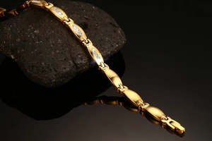 Close-up of gold-plated stainless steel bracelet with zircon stones and polished links