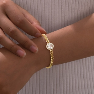 Detail of vintage gold Cuban chain bracelet with oval zircon gemstone worn by a model
