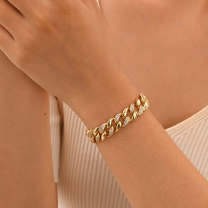 Close-up of gold Cuban link bracelet with pavé-set zircons on a model wrist