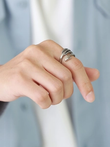 Close-up of vintage silver arrow ring featuring detailed feather textures on a male hand