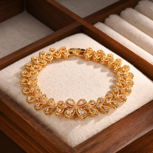 Detailed view of a gold flower bracelet with zircon stones inside a jewelry box
