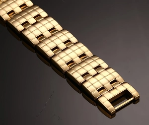 Macro shot of gold stainless steel bracelet links with intricate grid textured patterns