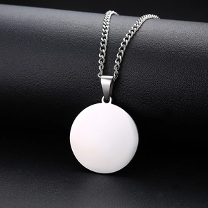 Vue détaillée du pendentif rond minimaliste en acier sur un fond en cuir noir