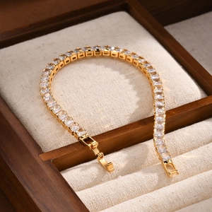 Close-up of gold tennis bracelet with square-cut cubic zirconia and fold-over clasp