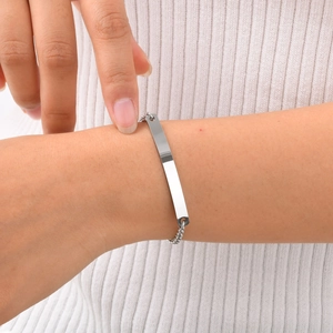 Close-up of minimalist silver stainless steel bar bracelet worn on female wrist