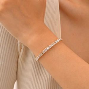Close-up of elegant gold plated tennis bracelet with square-cut cubic zirconia on a wrist