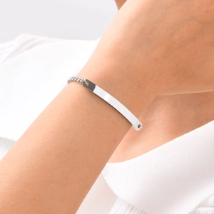Detailed view of a silver polished curved bar bracelet on a model's wrist