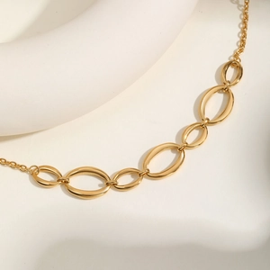 Détail d'un collier doré en acier inoxydable avec des maillons ovales entrelacés
