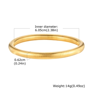 Macro detail of 14K gold-plated textured bangle with flexible spring coil structure