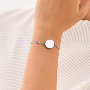 Close-up of polished stainless steel round locket pendant on a box chain bracelet