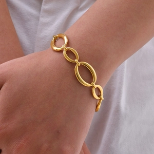 Detail eines goldenen Edelstahl-Gliederkettenarmbands am Handgelenk einer Frau