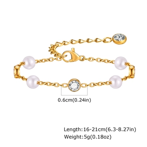 Dettaglio del bracciale con perle dorate, zirconi e chiusura a moschettone regolabile
