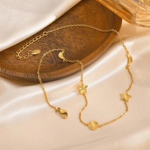 Detail der 18K vergoldeten Kette mit Mond-, Stern- und Sonnenanhängern auf Seide