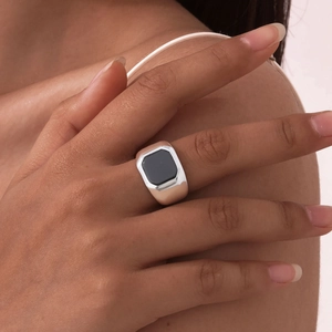 Gros plan d'une bague chevalière en acier inoxydable avec pierre d'onyx noire octogonale