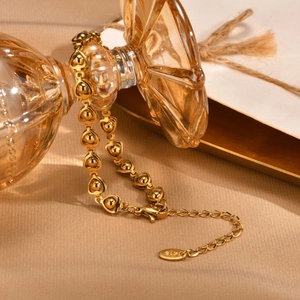 Detail view of 18K gold-plated stainless steel heart link bracelet with lobster clasp
