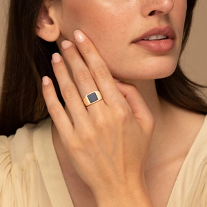Bague chevalière carrée dorée avec onyx noir et rayures verticales sur le côté de l'anneau