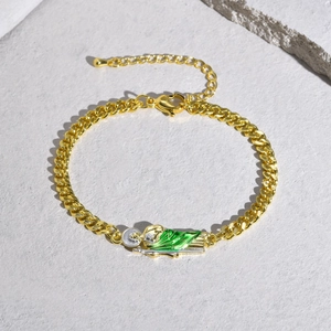 Close-up of Saint Jude Thaddeus pendant with green enamel on a golden Cuban chain bracelet