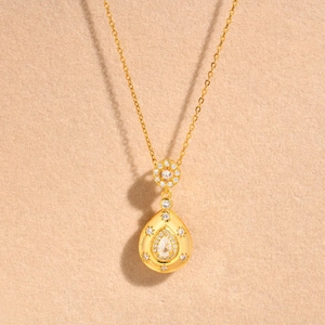 Élégant collier à pendentif goutte d'eau dorée avec zircons sur chaîne croisée