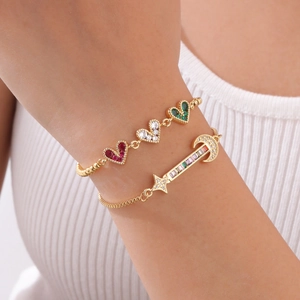 Bracelets dorés ajustables avec zircons colorés en forme de cœur portés au poignet