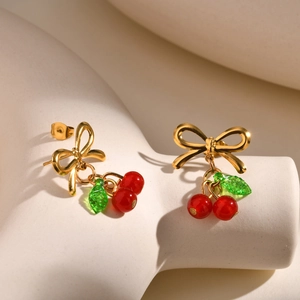 Boucles d'oreilles nœud doré avec pendentifs cerises rouges sur supports géométriques