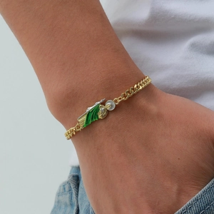 Close-up of gold San Judas Tadeo pendant on Cuban chain bracelet worn on wrist