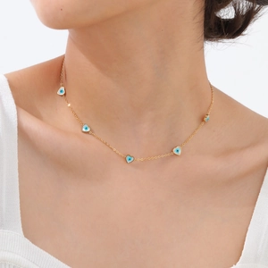 Dettaglio collana in oro a cinque petali con pendenti a cuore ed occhio azzurro