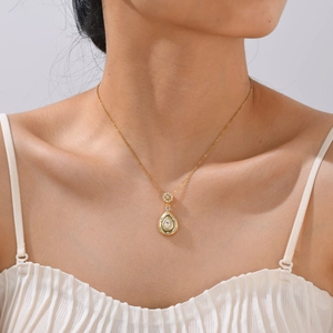 Détail du pendentif en zircone goutte d'eau sur une chaîne dorée portée par un mannequin