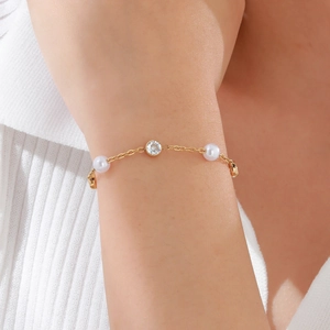 Elegante bracciale in acciaio dorato da donna con perle e uno zircone scintillante